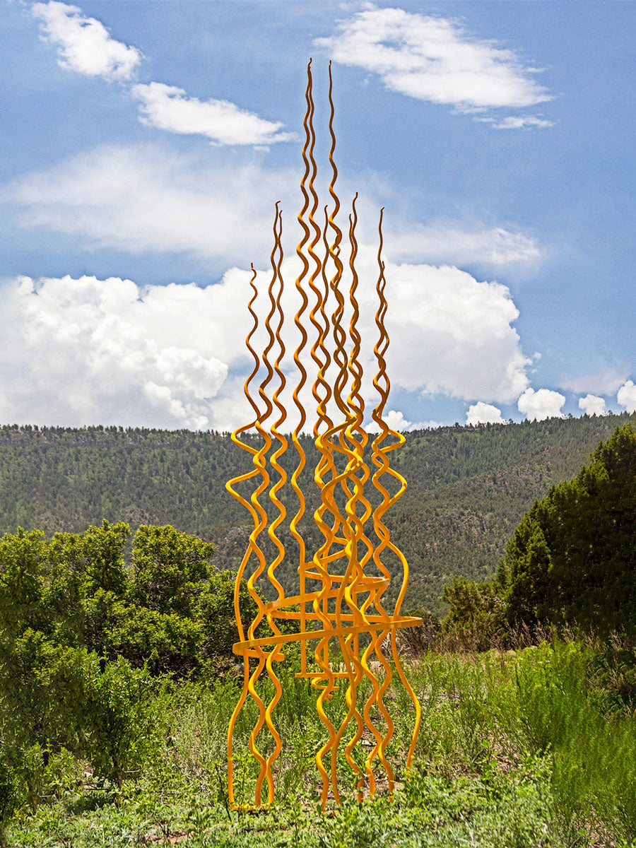 Large yellow sculpture in a mountain scape.  