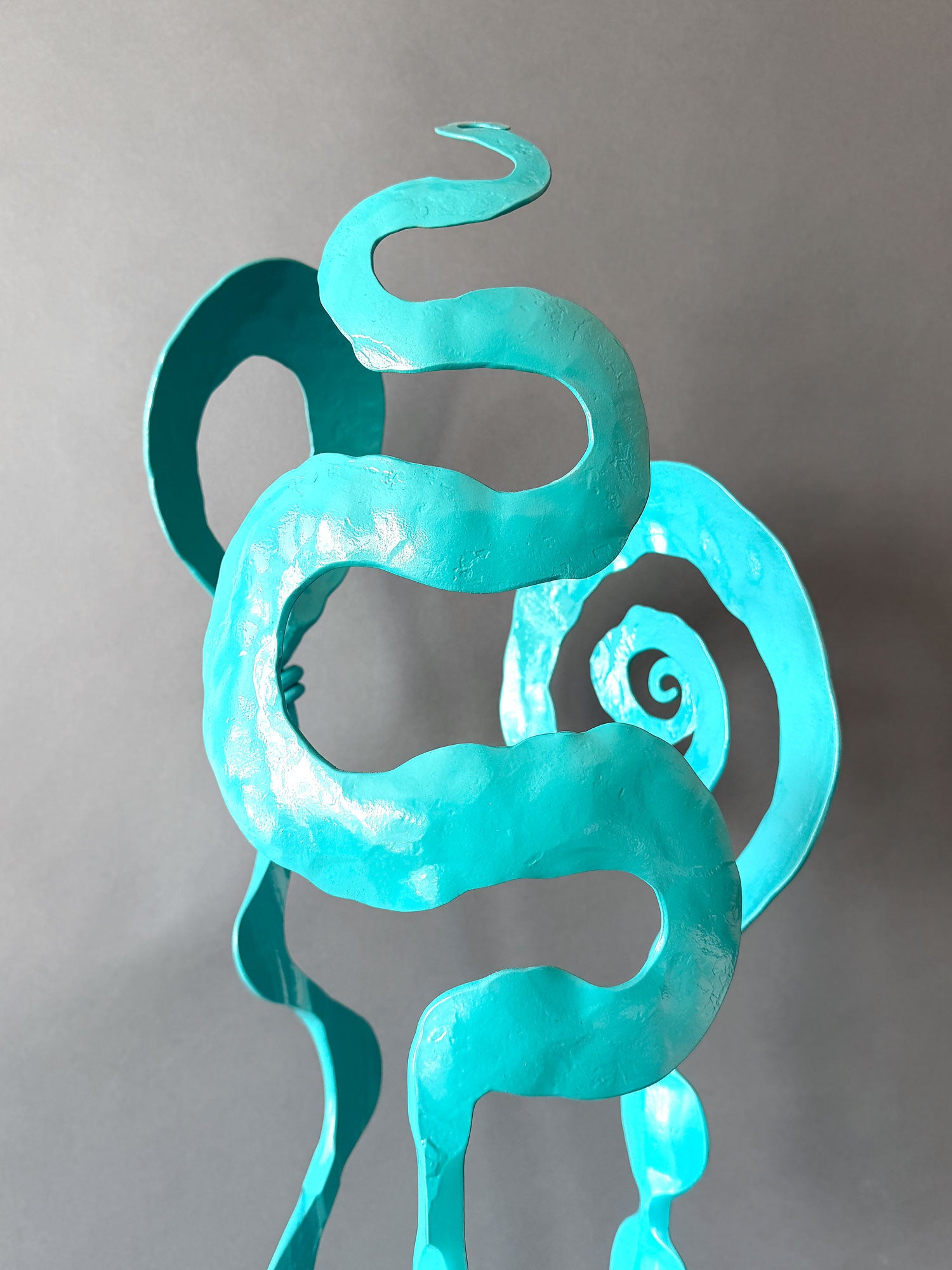 Close up of turquoise sculpture showing hand forged details.