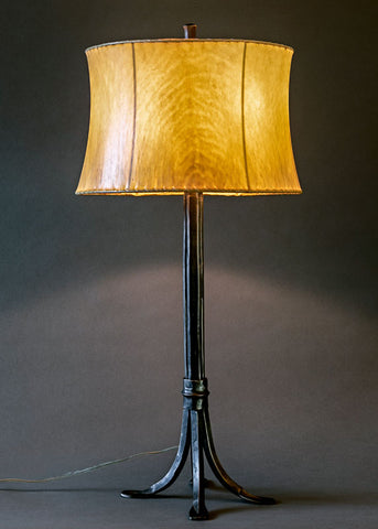 Hand forged wrought iron "Collard Sheave Lamp" shown in Rustic Black with a contemporary sheepskin shade.