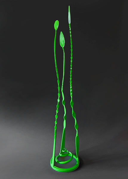 Green colored forged steel "Baby Pajos" free standing sculpture with three long tendrils pointing up.