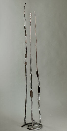 Metallic Pajo sculpture with three vertical pieces of hand forged steel attached to a spiral base. 