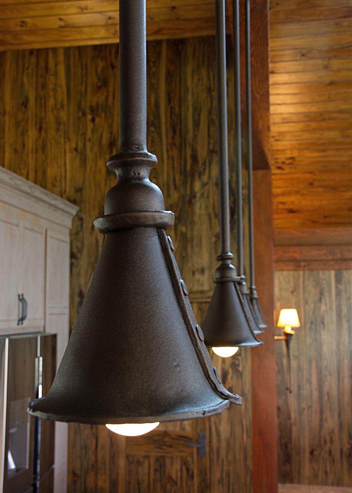 Four large wrought iron Ceiling Pendant Lights hanging from the ceiling in a row