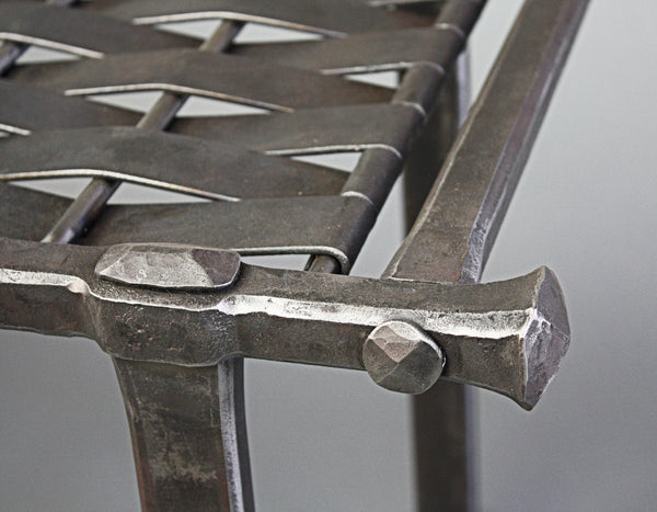 Close up of hand forged Woven Iron Bench corner. 