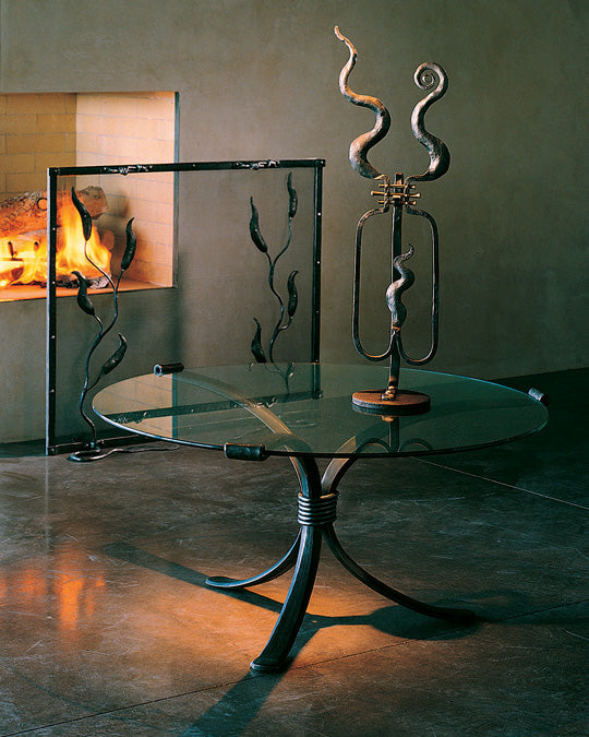 Round wrought iron coffee table with a glass top.