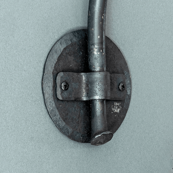 A hand forged round backplate used to mount wall sconces.