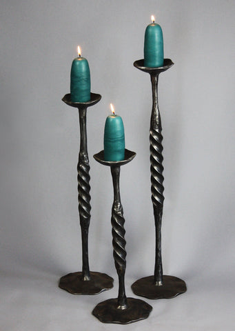 Three Pewter Black hand forged Spiral Candlestick holders made by blacksmith artist, Christopher Thomson - shown with large candles.