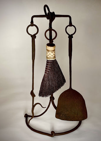 Wrought iron fireplace tool set with a fire poker, shovel and broom.
